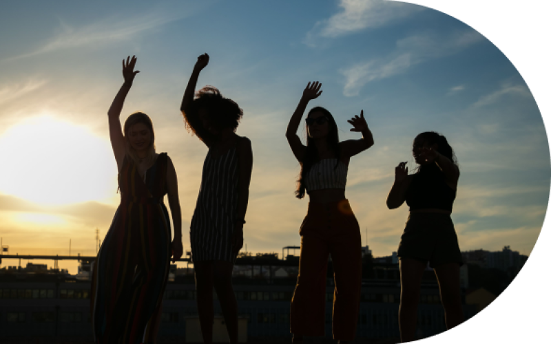 a group of women dancing with a sunset