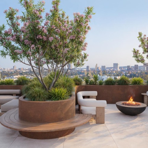 a patio with a fire pit and a tree with flowers and a city in the background